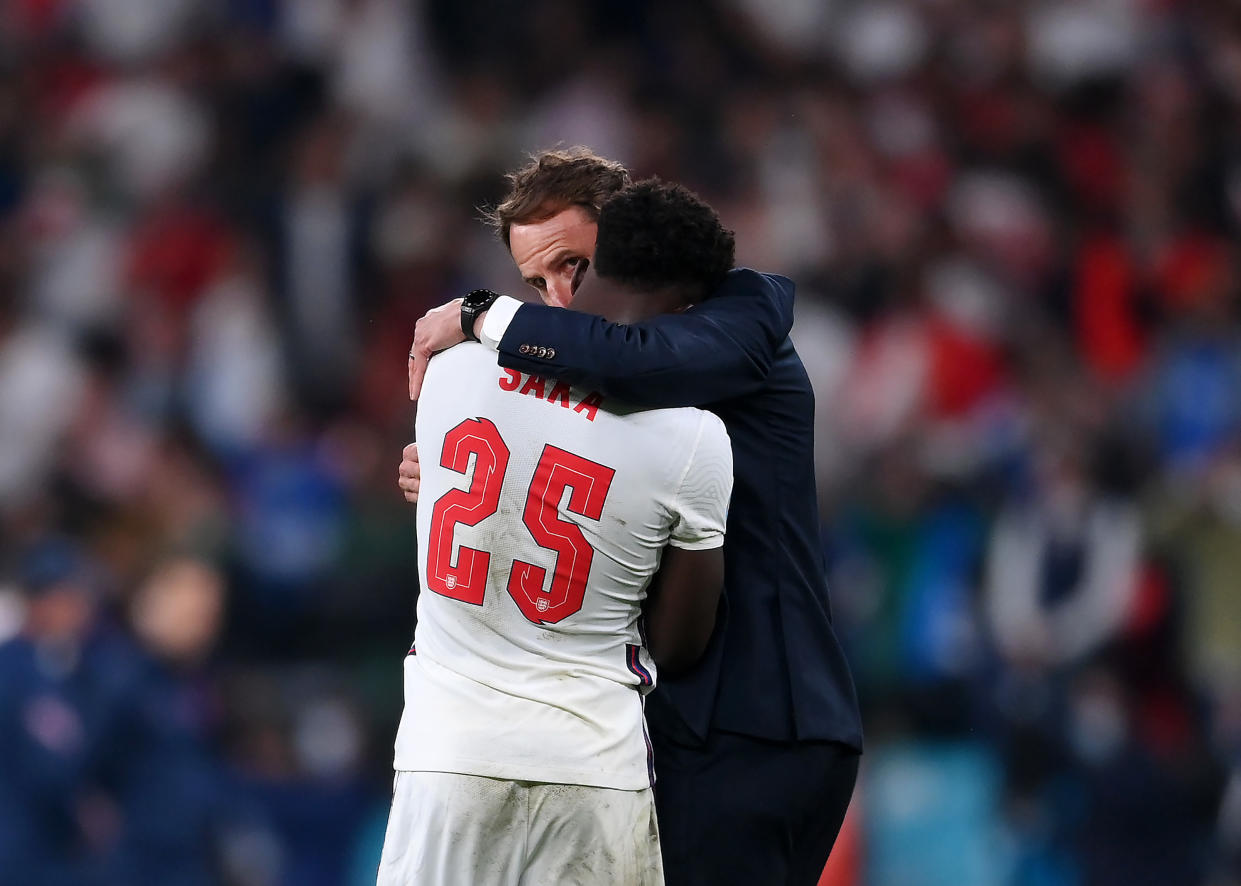 LONDON, ENGLAND - JULY 11: Bukayo Saka of England is consoled by Head Coach, Gareth Southgate after his penalty miss during the UEFA Euro 2020 Championship Final between Italy and England at Wembley Stadium on July 11, 2021 in London, England. (Photo by Laurence Griffiths/Getty Images)