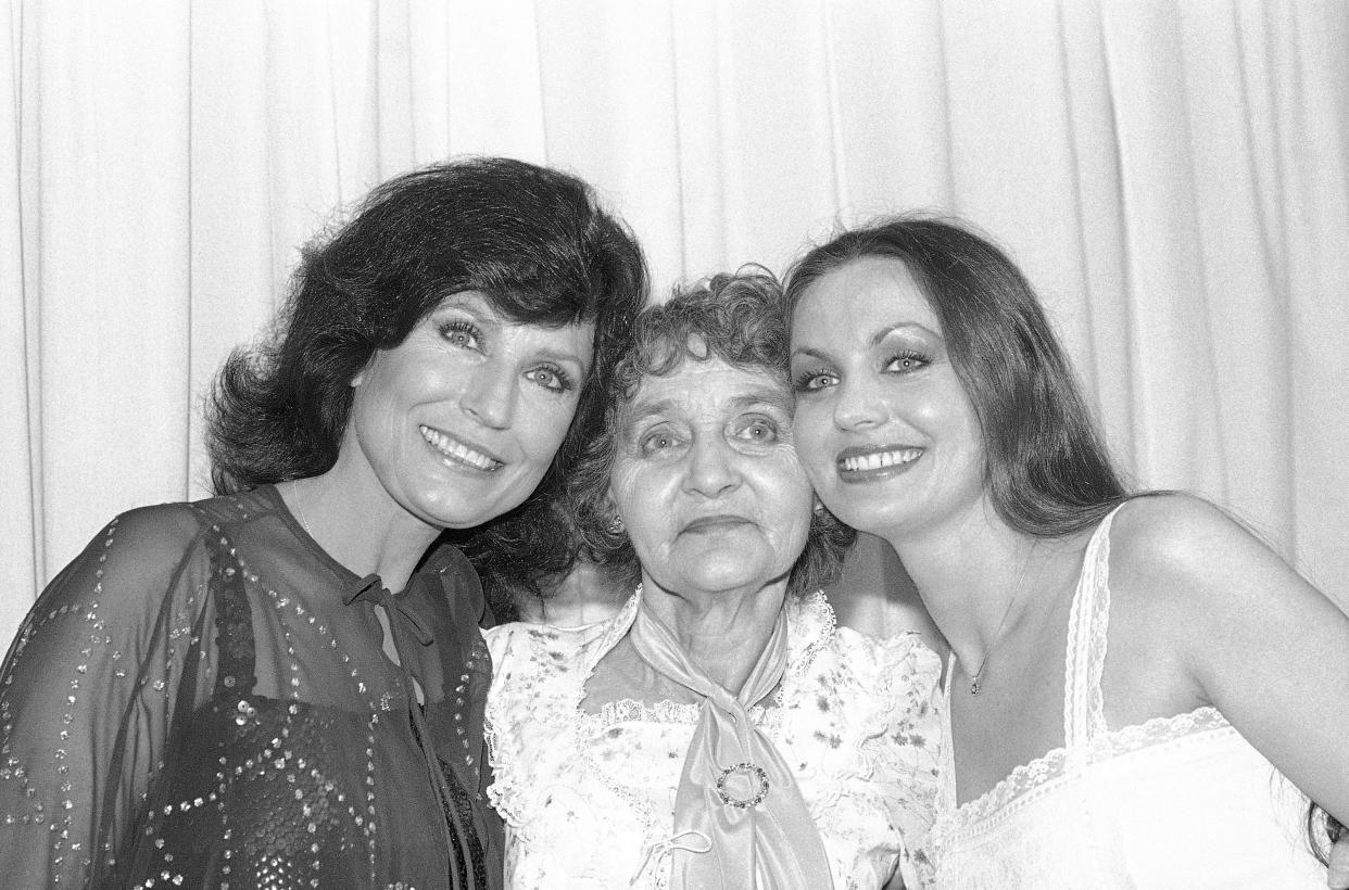 FILE - Country singers Loretta Lynn, left, and Crystal Gayle, right, poses with their mother Mrs. Clara Butcher, during ceremonies of the Academy of Country Music Awards in Buena Park, Calif. on May 2, 1980. Loretta Lynn was honored as the "Country Artist of the Decade" while Crystal Gayle won "Top Female Vocalist" for 1979. Lynn, the Kentucky coal miner’s daughter who became a pillar of country music, died Tuesday at her home in Hurricane Mills, Tenn. She was 90. (AP Photo/Lennox McLendon, File)