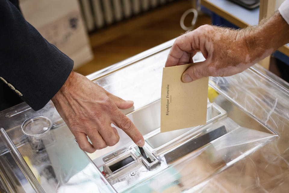 A voter casts his ballot at a voting station in Paris, Sunday, June 19, 2022. French voters are going to the polls in the final round of key parliamentary elections that will demonstrate how much legroom President Emmanuel Macron's party will be given to implement his ambitious domestic agenda. (AP Photo/Thomas Padilla)