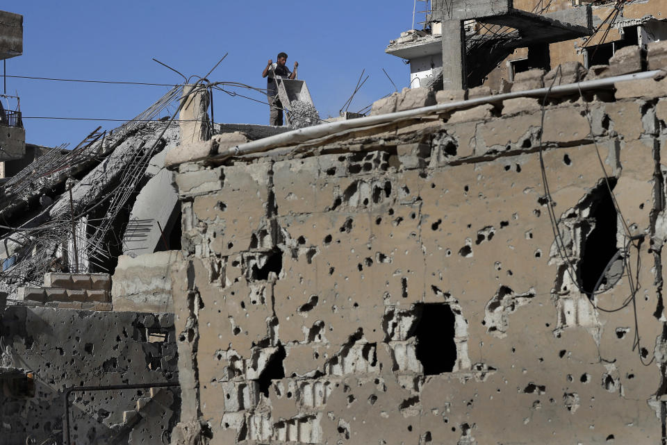 In this Thursday, April 5, 2018 photo, a man removes rubble from his house that was damaged during fighting between U.S.-backed Syrian Democratic Forces fighters and Islamic State militants, in Raqqa, Syria. U.S. President Donald Trump's decision Wednesday Dec. 19, 2018, to withdraw U.S. troops from Syria has rattled Washington's Kurdish allies, who are its most reliable partner in Syria and among the most effective ground forces battling the Islamic State group. (AP Photo/Hussein Malla, FILE)