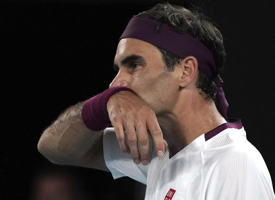 Switzerland's Roger Federer wipes the sweat from his face during his fourth round match against Hungary's Marton Fucsovics at the Australian Open tennis championship in Melbourne, Australia, Sunday, Jan. 26, 2020. (AP Photo/Lee Jin-man)