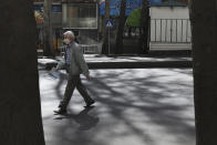 A man wearing a face mask and gloves to protect against the new coronavirus crosses the street in northern Tehran, Iran, Saturday, April 4, 2020. In the first working day after Iranian New Year holidays authorities have allowed some government offices and businesses to re-open with limited working hours, when schools, universities, and many businesses still are ordered to be closed aimed to prevent the spread of the virus. (AP Photo/Vahid Salemi)