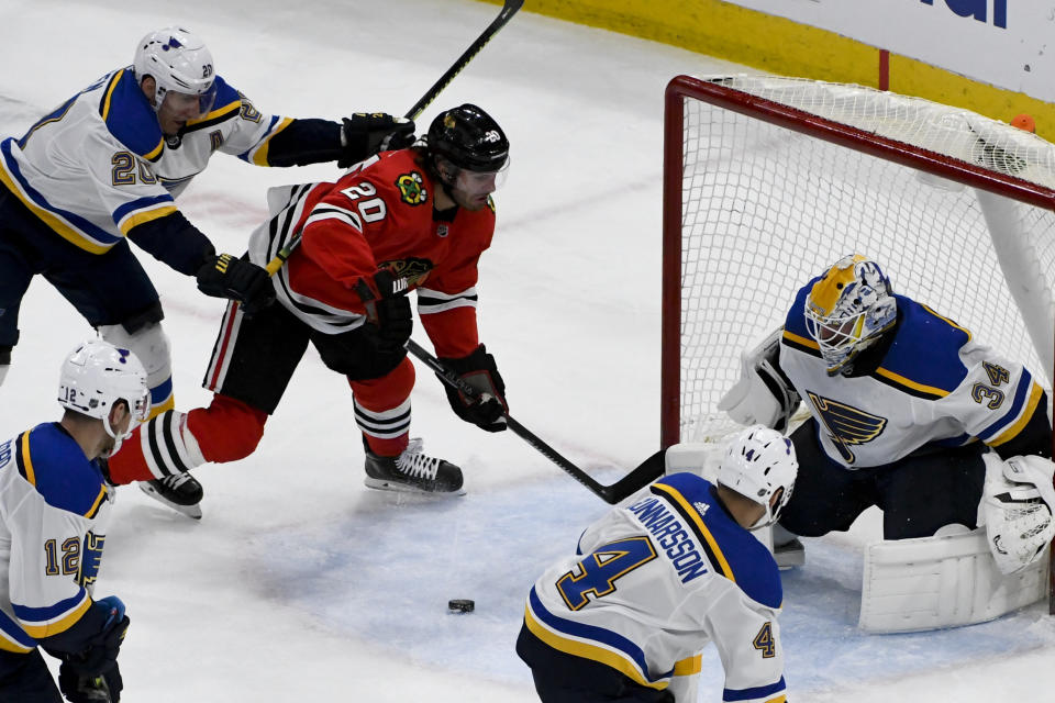 St. Louis Blues goaltender Jake Allen (34), defenseman Carl Gunnarsson (4) and left wing Alexander Steen (20) defend against Chicago Blackhawks left wing Brandon Saad (20) during the second period of an NHL hockey game between the Chicago Blackhawks and the St. Louis Blues on Sunday March 8, 2020, in Chicago. (AP Photo/Matt Marton)