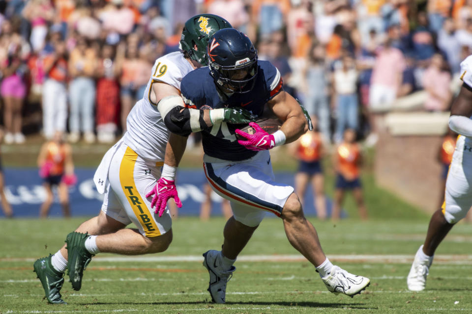 Virginia tight end Sackett Wood Jr. (44) fights for extra yards after a catch as he's brought down by William & Mary linebacker Kevin Jarrell (19) during the first half of an NCAA college football game Saturday, Oct. 7, 2023, in Charlottesville, Va. (AP Photo/Mike Caudill)