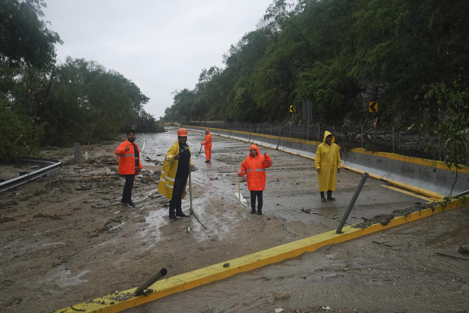 Trabajadores limpian una carretera bloqueada tras el paso del huracán Otis cerca de Acapulco, México, el miércoles 25 de octubre de 2023. (AP Foto/Marco Ugarte)
