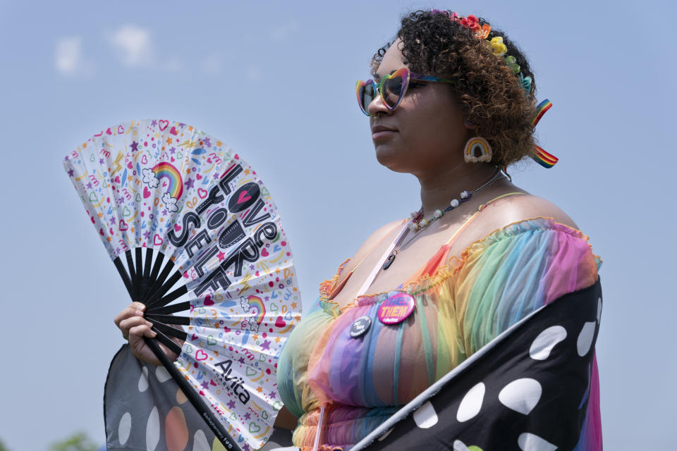 Wren uses a fan to keep cool during the Franklin Pride TN festival, Saturday, June 3, 2023, in Franklin, Tenn. (AP Photo/George Walker IV)