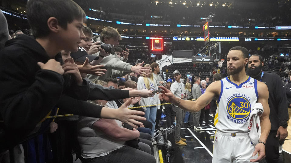 Fans reach for Golden State Warriors guard Stephen Curry (30) following an NBA basketball game against the Utah Jazz, Monday, Feb. 12, 2024, in Salt Lake City. (AP Photo/Rick Bowmer)