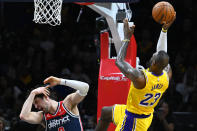 Los Angeles Lakers forward LeBron James, right, shoots against Washington Wizards forward Deni Avdija during the first half of an NBA basketball game Wednesday, April 3, 2024, in Washington. James was called for a flagrant foul. (AP Photo/John McDonnell)