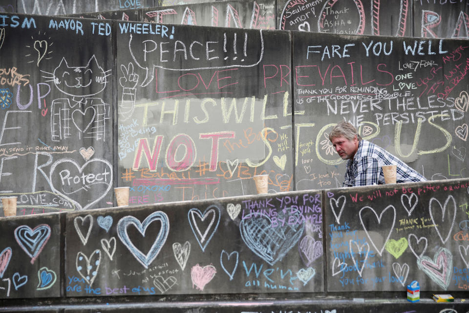 <p>A passerby bicycles through a makeshift memorial for two men who were killed on a commuter train while trying to stop another man from harassing two young women who appeared to be Muslim, in Portland, Ore., May 29, 2017. (Terray Sylvester/Reuters) </p>