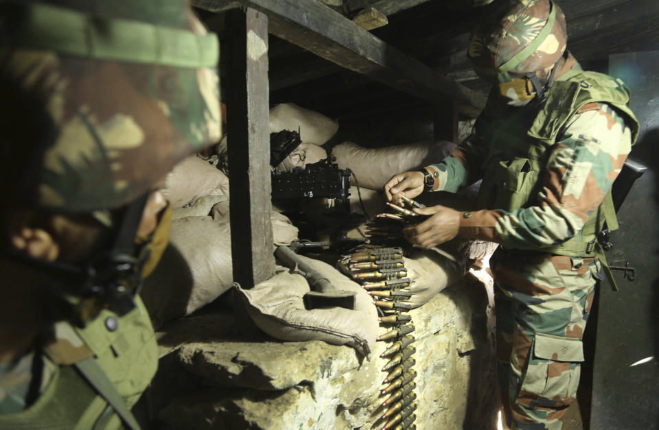 Indian army soldiers prepare a light machine gun in their bunker at a forward post along the Line of Control (LOC) between India and Pakistan border in Poonch, about 250 kilometers (156 miles) from Jammu, India, Friday, Dec. 18, 2020. Tens of thousands of soldiers from India and Pakistan are positioned along the two sides. The apparent calm is often broken by the boom of blazing guns, with each side accusing the other of initiating the firing. (AP Photo/Channi Anand)