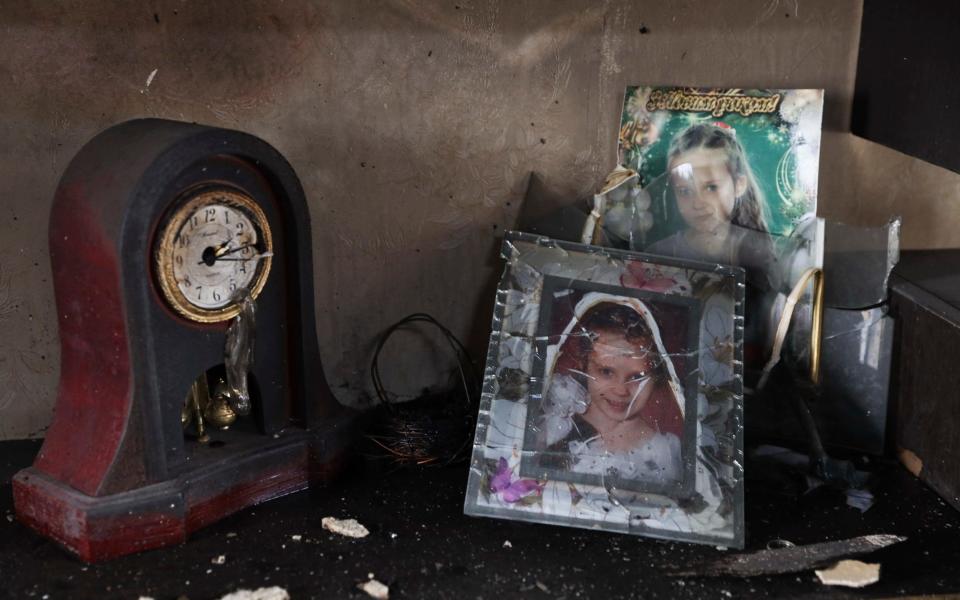 stand near the clock that stopped in the rocket attack in a damaged house in Zaporizhzhia, Ukraine, Sunday, April 9, 2023. ) - AP Photo/Kateryna Klochko