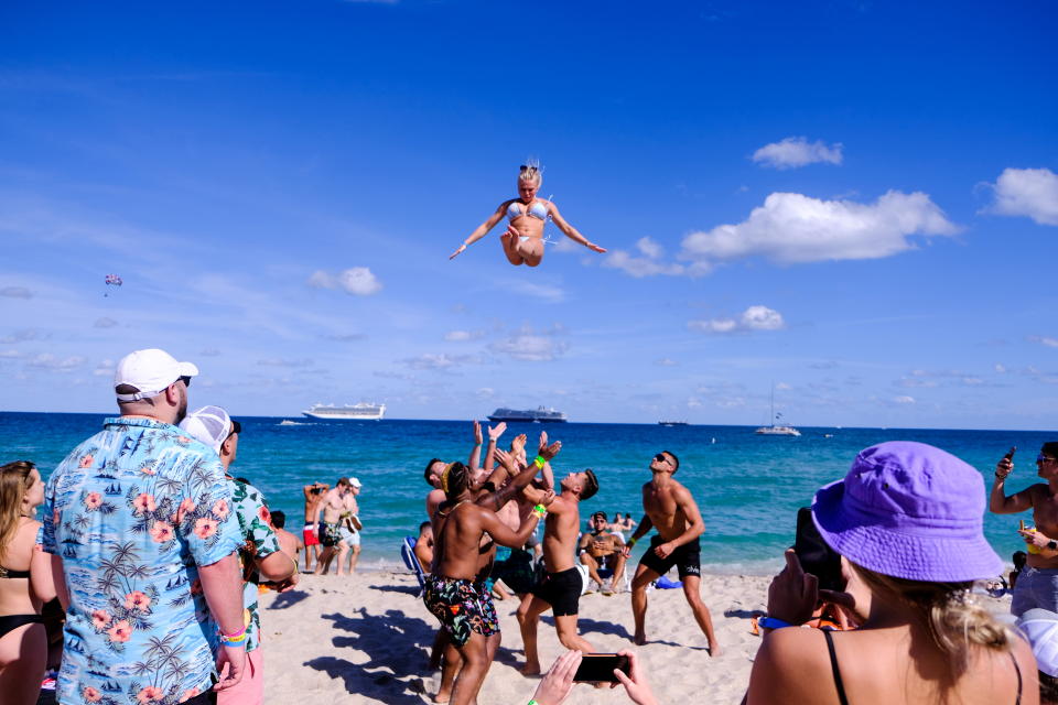 A college athlete is thrown in the air by a group of men on the beach to celebrate spring break, amid the coronavirus disease (COVID-19) outbreak in Fort Lauderdale, Florida, U.S., March 5, 2021.  REUTERS/Maria Alejandra Cardona     TPX IMAGES OF THE DAY