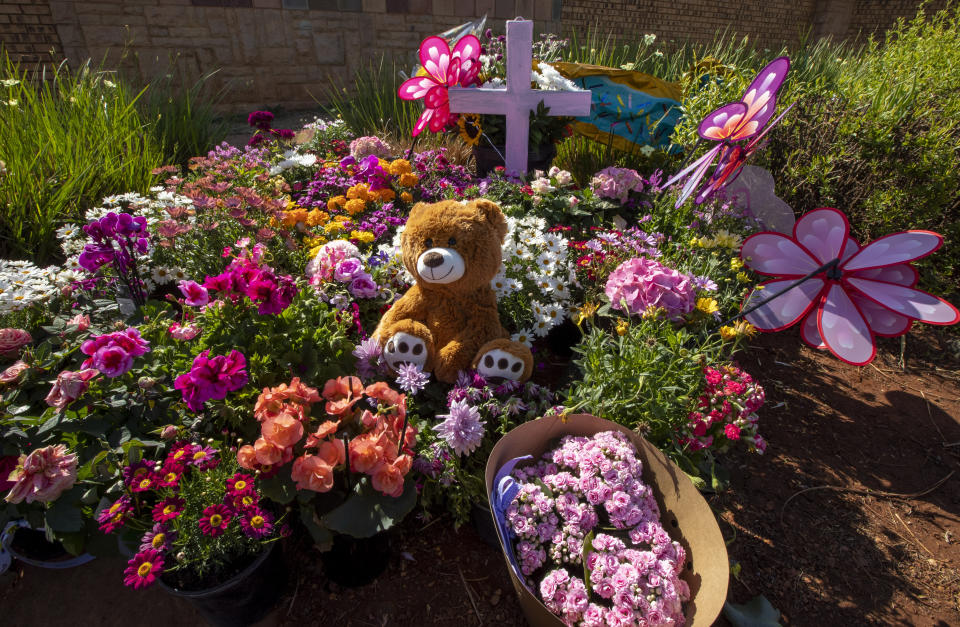 Flowers placed outside the complex where the Dickason family lived prior to their emigration to New Zealand, in Pretoria, South Africa, Thursday, Sept. 23, 2021. People in the town of Timaru are planning an evening vigil outside the home of three young girls who were killed last week in a crime that shocked New Zealand. The girls' mother Lauren Dickason has been charged with their murder. (AP Photo/Themba Hadebe)