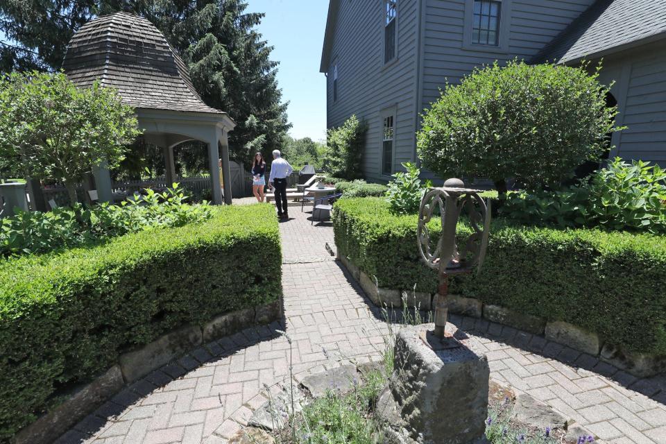 Visitors tour the English-style garden Saturday at a home on Parkside Drive.