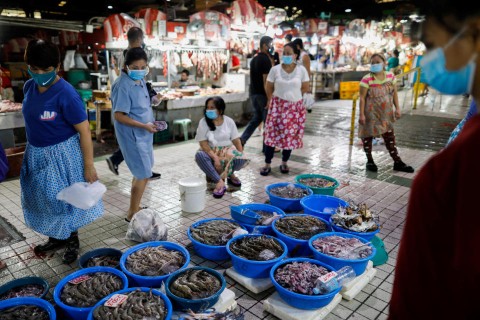 Vendors and customers wear masks for protection against the coronavirus disease (COVID-19) while making transactions at a market in Quezon City, Metro Manila, Philippines, July 21, 2020. REUTERS/Eloisa Lopez