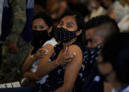 A woman reacts after getting her shot of Russia's Sputnik V coronavirus vaccine during a vaccination drive at University Stadium in Mexico City, Friday, July 23, 2021. So far, about 42.4 million people have been vaccinated, according to the health ministry. That is about 47% of the adult population, and about 30% of the total population. (AP Photo/Fernando Llano)