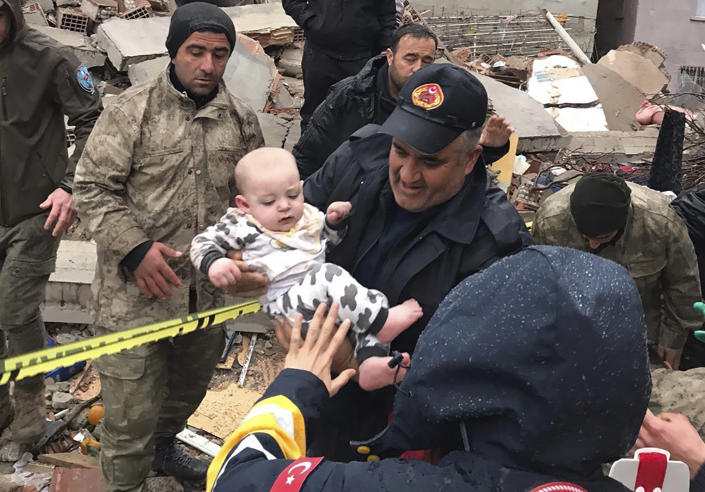 A baby is rescued from a destroyed building in Malatya, Turkey, Monday, Feb. 6, 2023. A powerful quake has knocked down multiple buildings in southeast Turkey and Syria and many casualties are feared. (DIA Images via AP)