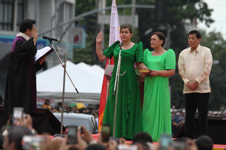 Sara Duterte, the daughter of outgoing populist president of the Philippines, takes her oath as vice president during rites in her hometown in Davao city, southern Philippines, Sunday June 19, 2022. Duterte clinched a landslide electoral victory despite her father's human rights record that saw thousands of drug suspects gunned down. Also in photo are, from left; Supreme Court Justice Ramon Paul Hernando, her mother Elizabeth Zimmerman and Philippine President Rodrigo Duterte. (AP Photo/Manman Dejeto)