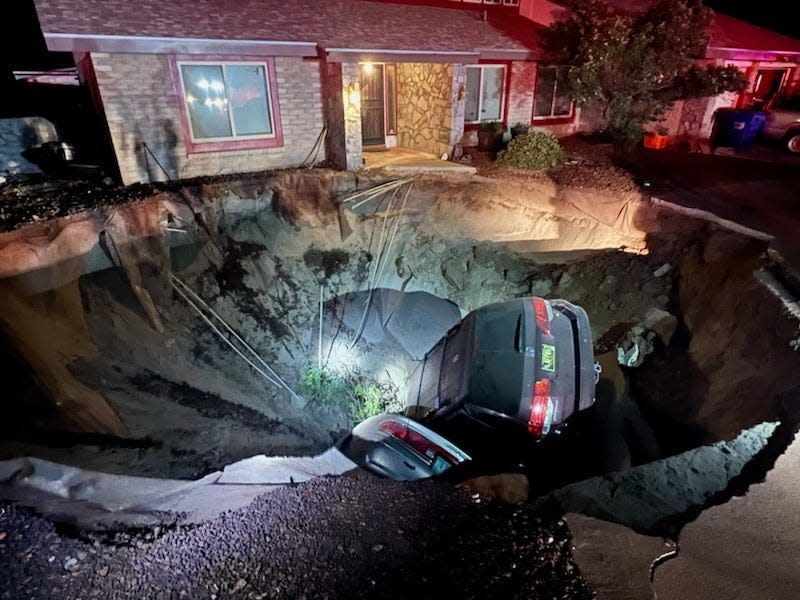 A large sinkhole on the 1700 block of Regal Ridge Street swallowed two vehicles and forced the temporary evacuation of occupants from three homes Monday evening.