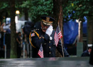 <p>A guest wipes a tear among names at the edge of the south reflecting pool at the National 9/11 Memorial and Museum during ceremonies marking the 17th anniversary of the September 11, 2001 attacks on the World Trade Center in New York, Sept. 11, 2018. (Photo: Brendan McDermid/Reuters) </p>