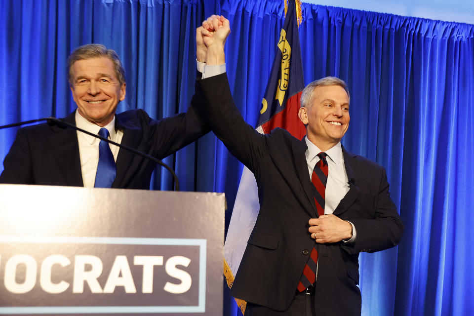 Democratic North Carolina gubernatorial candidate Josh Stein, right, is introduced by North Carolina Gov. Roy Cooper at a primary election night party in Raleigh, N.C., Tuesday, March 5, 2024. (AP Photo/Karl B DeBlaker)