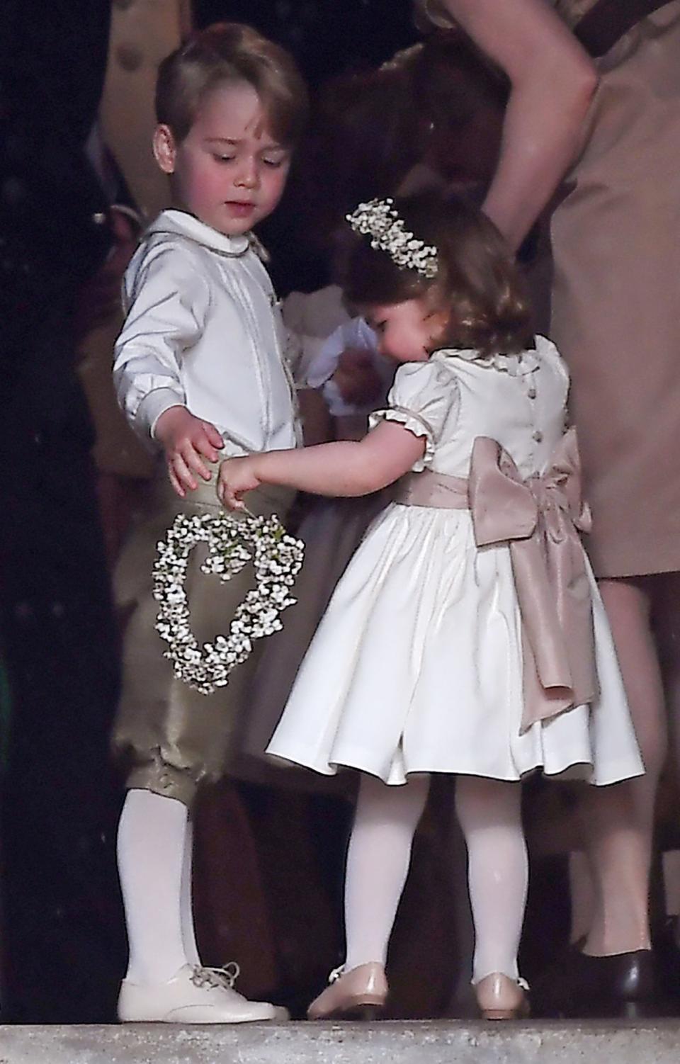 <p>The adorable young royals <a rel="nofollow" href="https://www.yahoo.com/style/prince-george-princess-charlotte-steal-spotlight-pippa-middletons-wedding-140616696.html" data-ylk="slk:wore bespoke outfits;elm:context_link;itc:0;sec:content-canvas;outcm:mb_qualified_link;_E:mb_qualified_link;ct:story;" class="link  yahoo-link">wore bespoke outfits</a> by Pepa & C for their page boy and flower girl roles. George was dressed in a white shirt and satin shorts while Charlotte served her wedding duties in a cute white dress with a pink bow. (Photo: PA) </p>