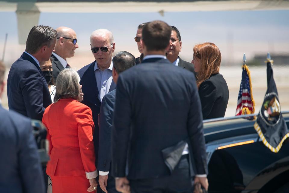 President Biden speaks to Governor Michelle Lujan Grisham, second from left, and Senator Martin Heinrich, left, after landing in Albuquerque at the Kirtland Air Force Base on Saturday, June 12, 2022.