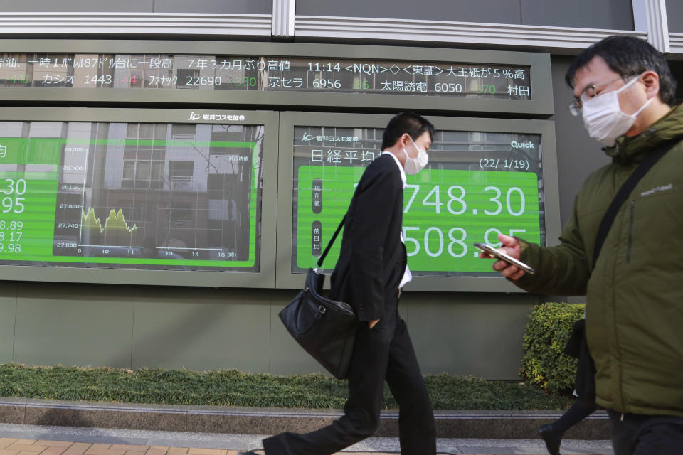 People walk by an electronic stock board of a securities firm in Tokyo, Wednesday, Jan. 19, 2022. Asian shares were lower Wednesday after a retreat on Wall Street. (AP Photo/Koji Sasahara)