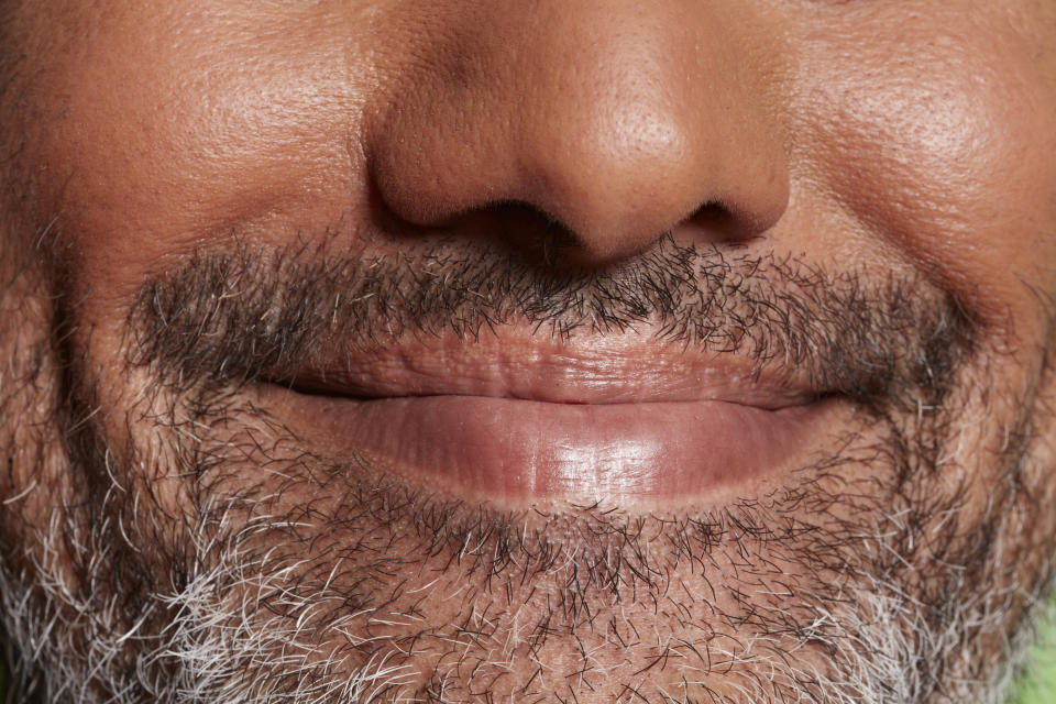 Close-up of a person's smile with a mustache, no identification possible