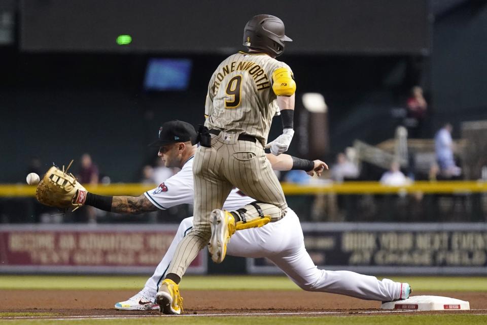 Arizona Diamondbacks first baseman Christian Walker, rear, reaches out to make a catch to get San Diego Padres' Jake Cronenworth (9) out at first base during the first inning of a baseball game Tuesday, June 28, 2022, in Phoenix. (AP Photo/Ross D. Franklin)