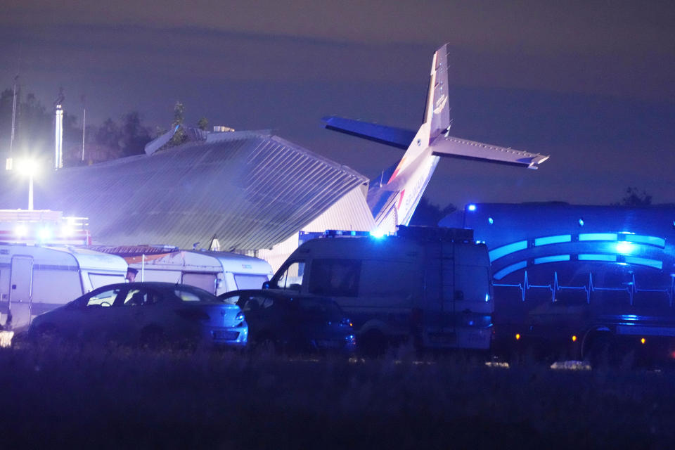 The tail of a Cessna 208 plane sticks out of a hangar after it crashed there in bad weather killing several people and injuring others, at a sky-diving centre in Chrcynno, central Poland, on Monday, July 17, 2023.(AP Photo/Czarek Sokolowski)