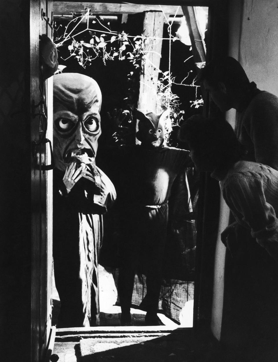 <p>Masked guests arrive at a fancy Halloween costume party circa 1956. </p>