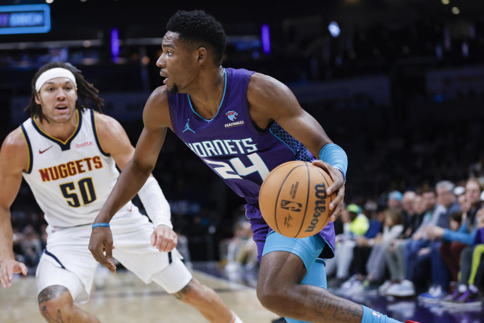 Charlotte Hornets forward Brandon Miller (24) drives the baseline past Denver Nuggets forward Aaron Gordon (50) during the first half of an NBA basketball game in Charlotte, N.C., Saturday, Dec. 23, 2023. (AP Photo/Nell Redmond)