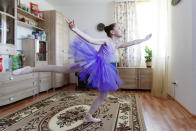 Alexandra Kustova, shows how she dances prior to an interview in her family's apartment in Yekaterinburg, a city in the Urals, Russia on Thursday, May 7, 2020. For 12-year-old Alexandra, self-isolation during the coronavirus pandemic turned out to be a blessing in disguise. Now that all the studies are conducted online, not only does she have more time for her two favorite hobbies _ ballet and jigsaw puzzles _ she spends more time with her family and helps out her grandmother, who lives in the same building two floors down. (AP Photo/Anton Basanaev)