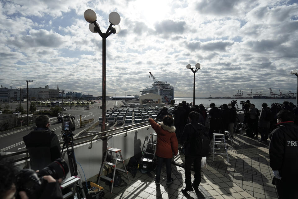 Media crews film the quarantined Diamond Princess cruise ship at a port in Yokohama, near Tokyo, Wednesday, Feb. 19, 2020. The cruise ship begins letting passengers off the boat on Wednesday after it's been in quarantined for 14 days. (AP Photo/Eugene Hoshiko)