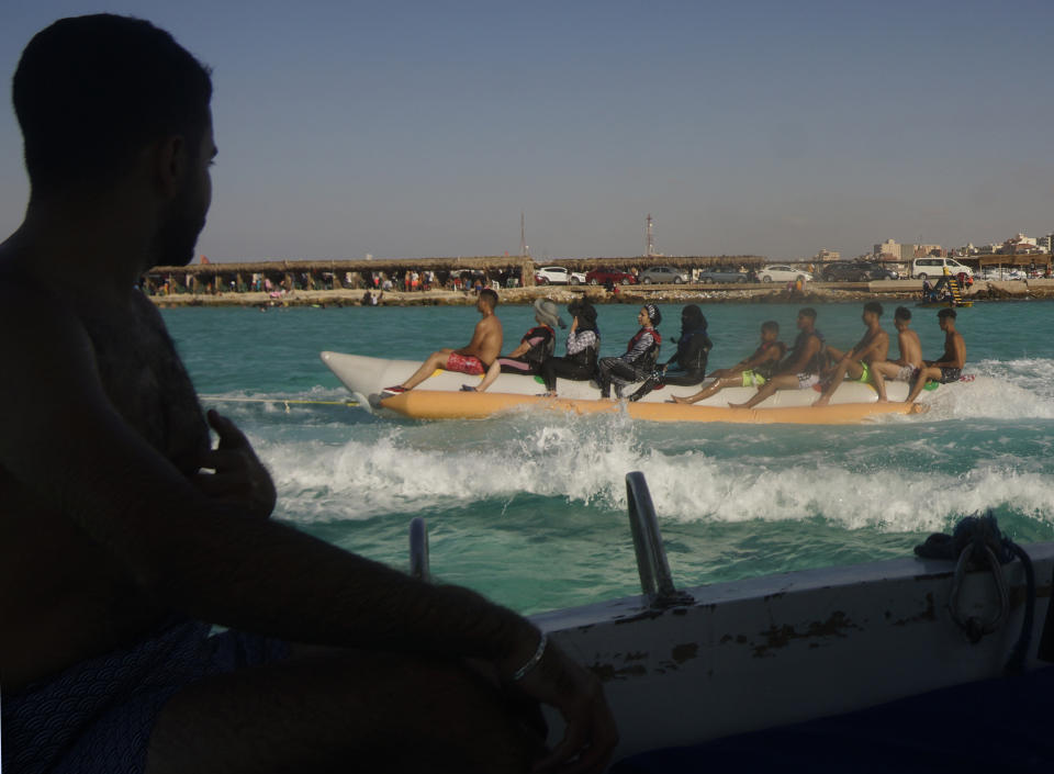 FILE - Egyptian holiday-makers ride on a banana boat at the beach of the Mediterranean city of Marsa Matrouh, 270 miles (430 kilometers) northwest of the capital, Cairo, Egypt, Aug. 13, 2022. While vacationers might enjoy the Mediterranean sea’s summer warmth, climate scientists are warning of dire consequences for its marine life as it burns up in a series of severe heat waves. (AP Photo/Amr Nabil, File)