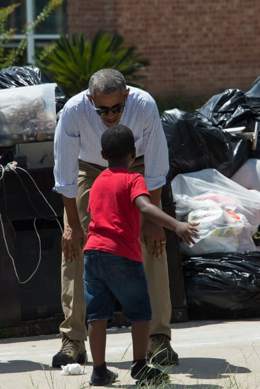 US President Barack Obama speaks with 6-year-old Jacolson Kelley as he tours a flood-affected area in Baton Rouge, Louisiana, on August 23, 2016