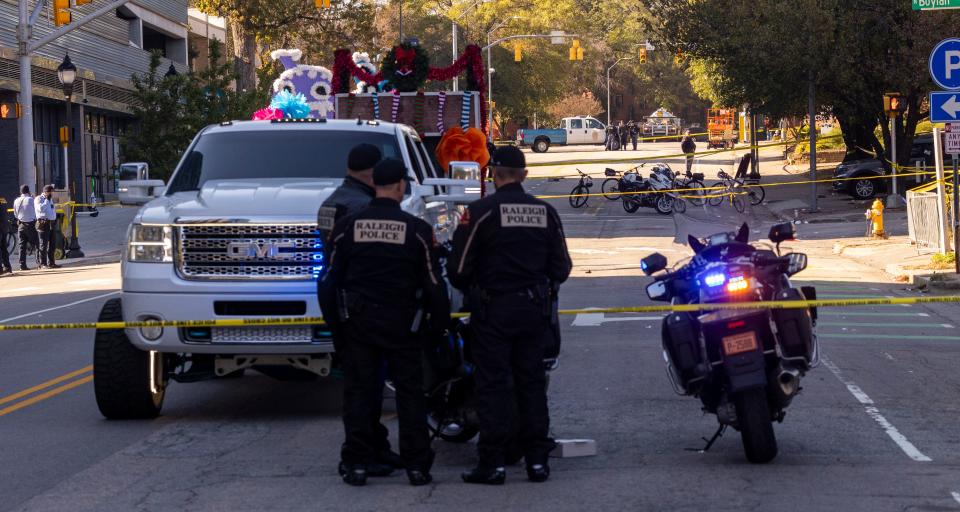 Police officers work the scene after a truck pulling a float crashed at a holiday parade in Raleigh, N.C., on Saturday, Nov. 19, 2022. Witnesses say people attending the Raleigh Christmas Parade heard the truck's driver screaming that he had lost control of the vehicle and couldn't stop it before the crash.