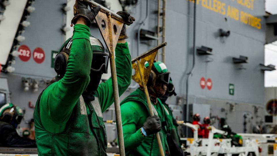 Hook runners wait for aircraft to land on the flight deck of the carrier Gerald R. Ford in the Atlantic Ocean off the U.S. coast Oct. 6, 2022. (Samuel Corum/AFP via Getty Images)