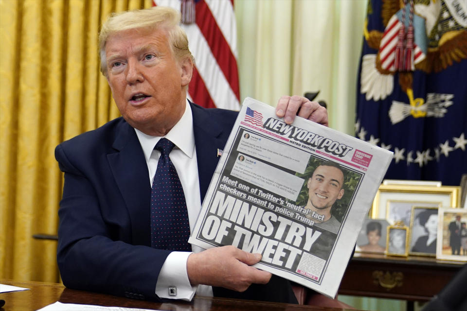 President Donald Trump holds up a copy of the New York Post as he speaks before signing an executive order aimed at curbing protections for social media giants, in the Oval Office of the White House, Thursday, May 28, 2020, in Washington. (AP Photo/Evan Vucci)