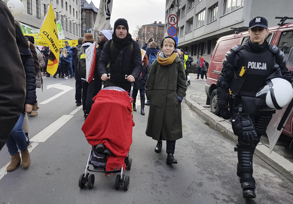 Michal Dabrowski, left, Anna Zalikowska attend their daughter attend a climate march in Katowice, Poland, on Saturday, Dec 8, 2018. (AP Photo/Frank Jordans)