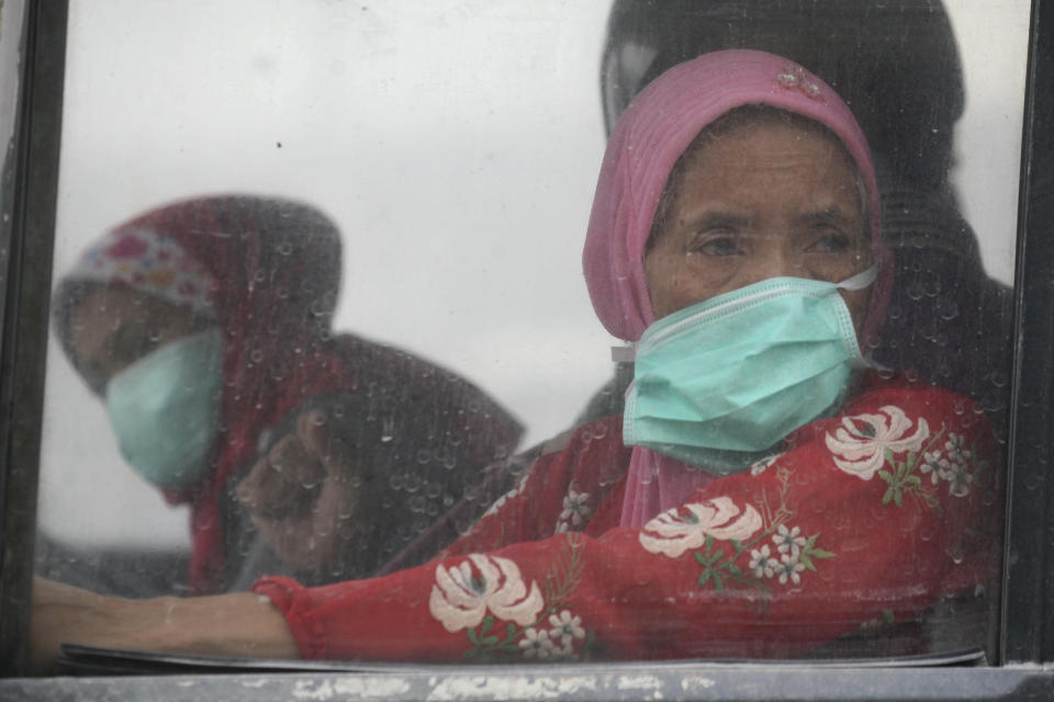 Elderly woman wearing masks are evacuated on a bus following an eruption of Mount Kelud, in Malang, East Java, Indonesia, Saturday, Feb. 15, 2014. The powerful volcanic eruption on Indonesia's most populous island blasted ash and debris 18 kilometers (12 miles) into the air Friday, forcing authorities to evacuate more than 100,000 and close seven airports. (AP Photo/Trisnadi)