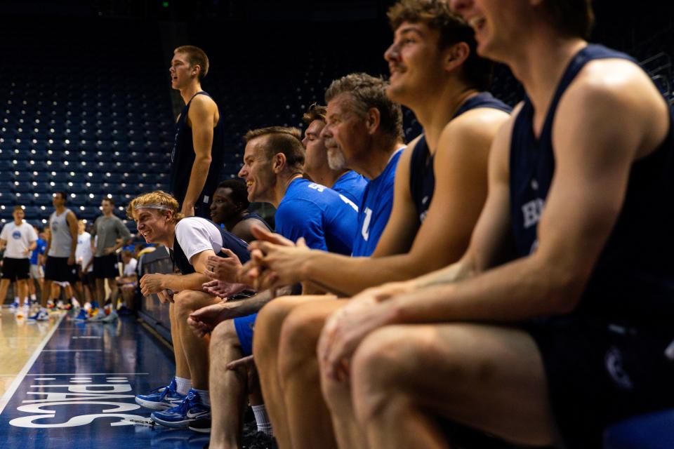 Members of the media, BYU basketball players and members of the BYU coaching staff watch the basketball game from the bench at Media Madness, an event hosted by the school, at the Marriott Center in Provo on Monday, Oct. 9, 2023. | Megan Nielsen, Deseret News