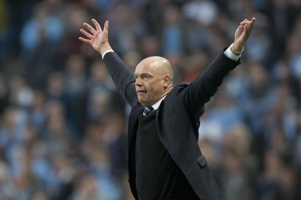 FILE - In this Sunday, March 9, 2014 file photo, Wigan's manager Uwe Rosler celebrates as his team beat Manchester City 2-1 during their English FA Cup quarterfinal soccer match at the Etihad Stadium, Manchester, England. Wigan Athletic hadn’t won a piece of major silverware in its 81-year history until last May, when it pulled off one of the great FA Cup upsets by beating big-spending Manchester City in the final. Now, despite dropping out of the Premier League at the end of last season, it is on course to retain the famous trophy against all the odds. (AP Photo/Jon Super, File)