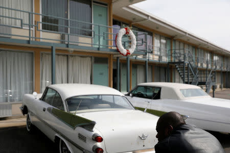 A man sits outside the Lorraine Motel where Martin Luther King Jr. stayed before he was shot and killed in 1968, now the National Civil Rights Museum, in Memphis, Tennessee, U.S., March 25, 2018. REUTERS/Jonathan Ernst