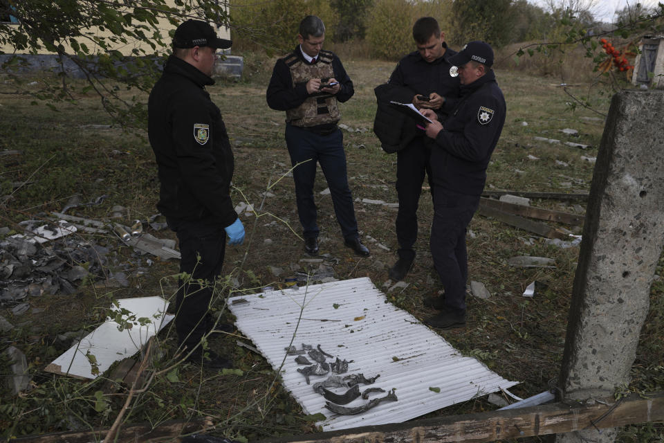 Police officers inspect the fragments of a Russian missile in the village of Hroza near Kharkiv, Ukraine, Friday, Oct. 6, 2023. Ukrainian officials say at least 51 civilians were killed in a Russian rocket strike on a village store and cafe in the eastern part of the country in one of the deadliest attacks in recent months. (AP Photo/Alex Babenko)