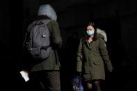 A woman in a face mask walks in the downtown area of Manhattan, New York City, after further cases of coronavirus were confirmed in New York