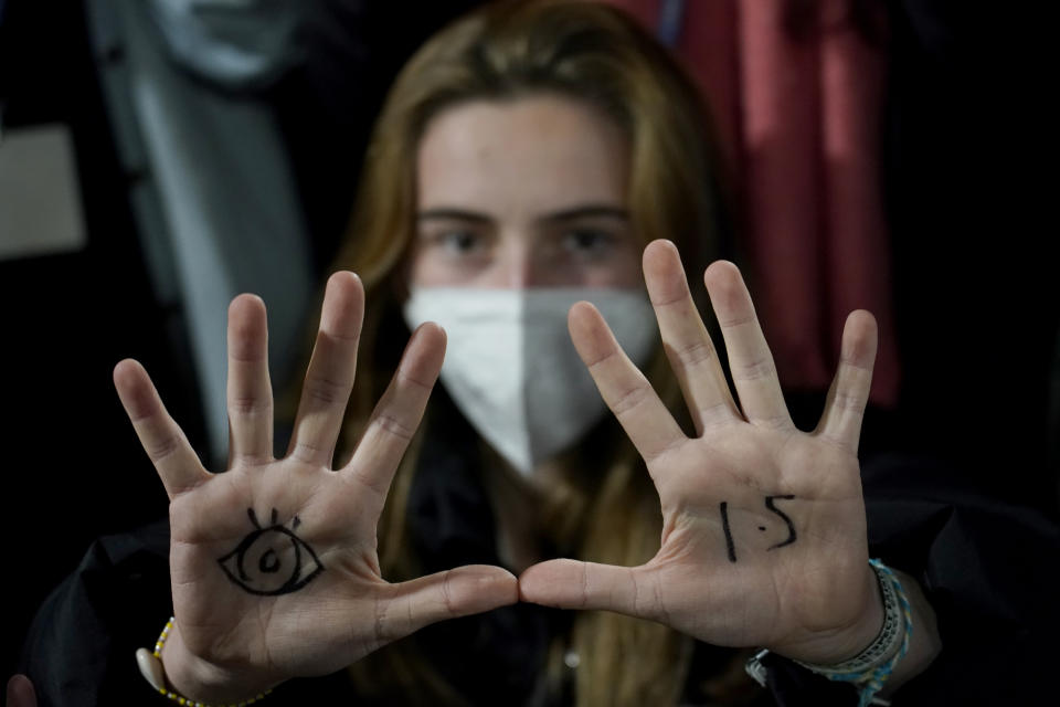 A woman, with an eye drawn on her hand to show she is watching and 1.5 for countries to limit warming to 1.5 degrees Celsius, takes part in a protest inside a plenary corridor at the SEC (Scottish Event Campus) venue for the COP26 U.N. Climate Summit, in Glasgow, Scotland, Wednesday, Nov. 10, 2021. The U.N. climate summit has entered its second week, and leaders from around the world are gathering to lay out their vision for addressing the common challenge of global warming. (AP Photo/Alberto Pezzali)