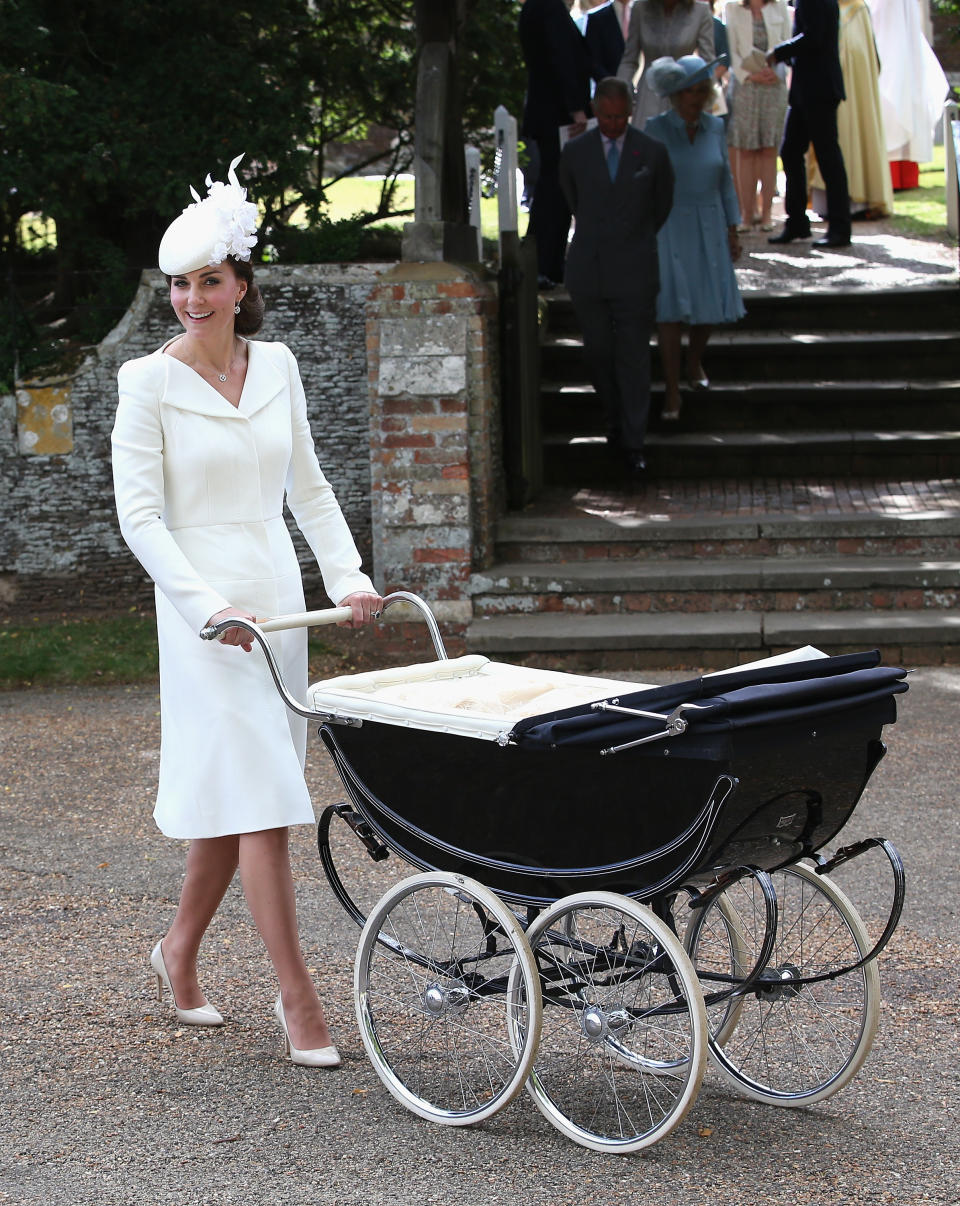 <p>The Duchess wore a bespoke white Alexander McQueen coat dress for Princess Charlotte’s christening. Teaming the look with a matching floral Jane Taylor hat, Kate finished with nude Russell & Bromley heels. <em>[Photo: Getty]</em> </p>