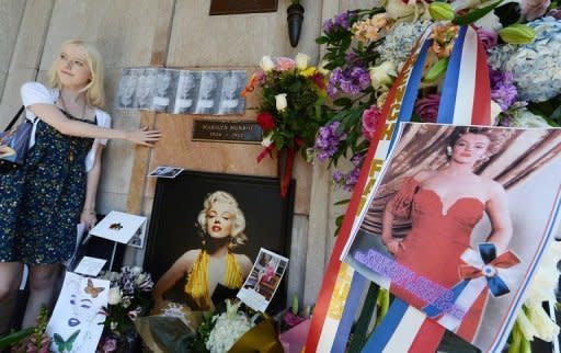 A Marilyn Monroe fan pays her respects at the crypt where the star lays before a memorial service to mark the 50th anniversary of her death at Westwood Village Memorial Park Cemetery in Los Angeles on August 5